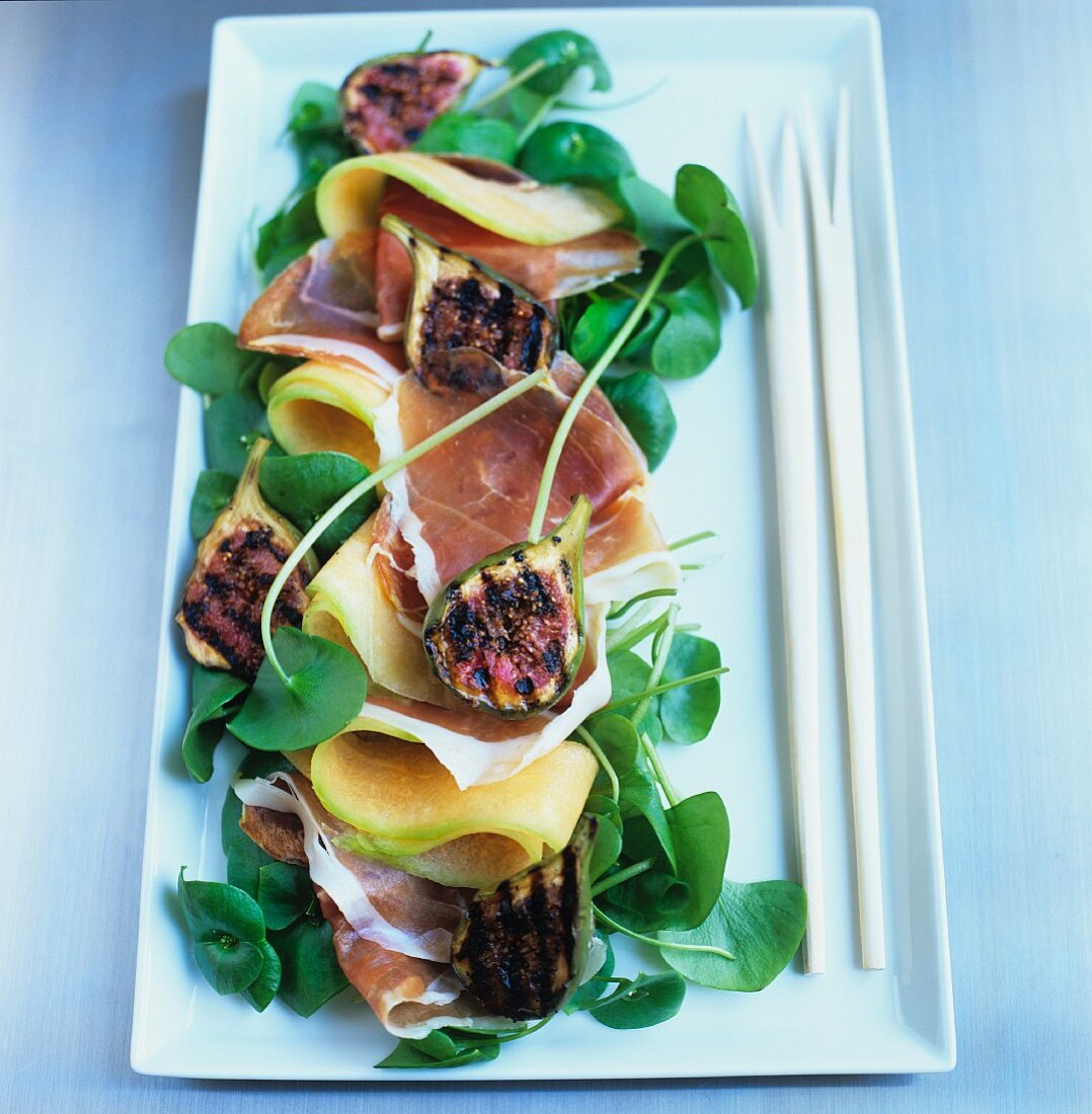 Melon with ham and grilled figs on watercress