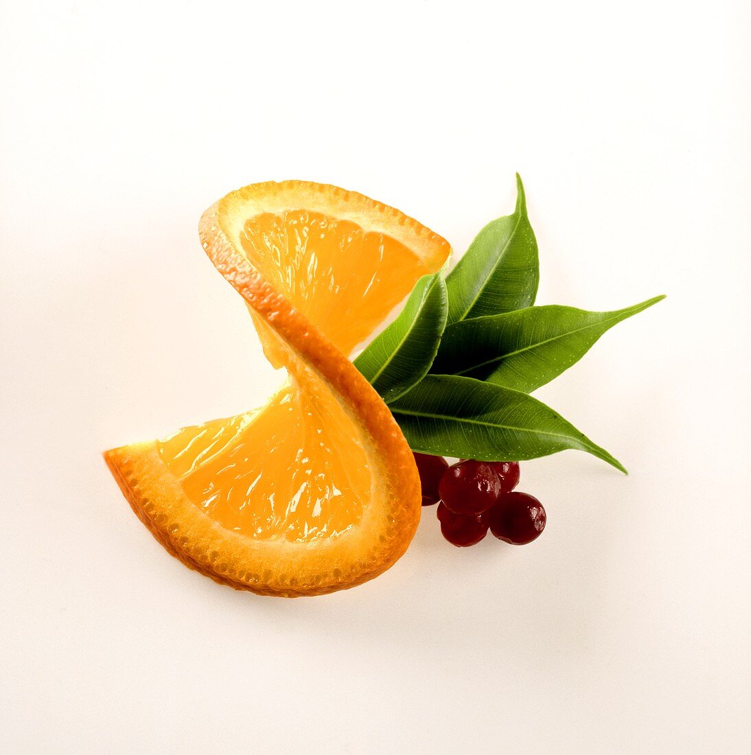 Slice of orange with cranberries and leaves