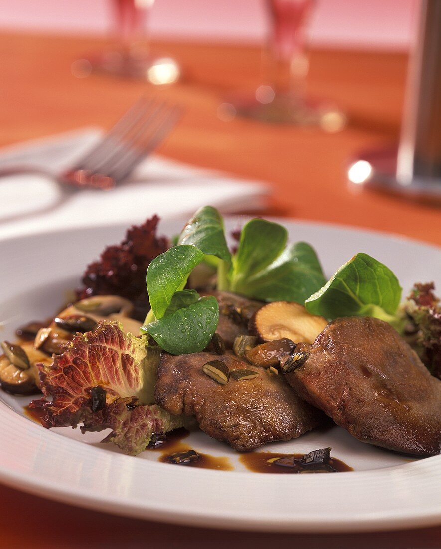 Green salad with fried chicken liver and mushrooms