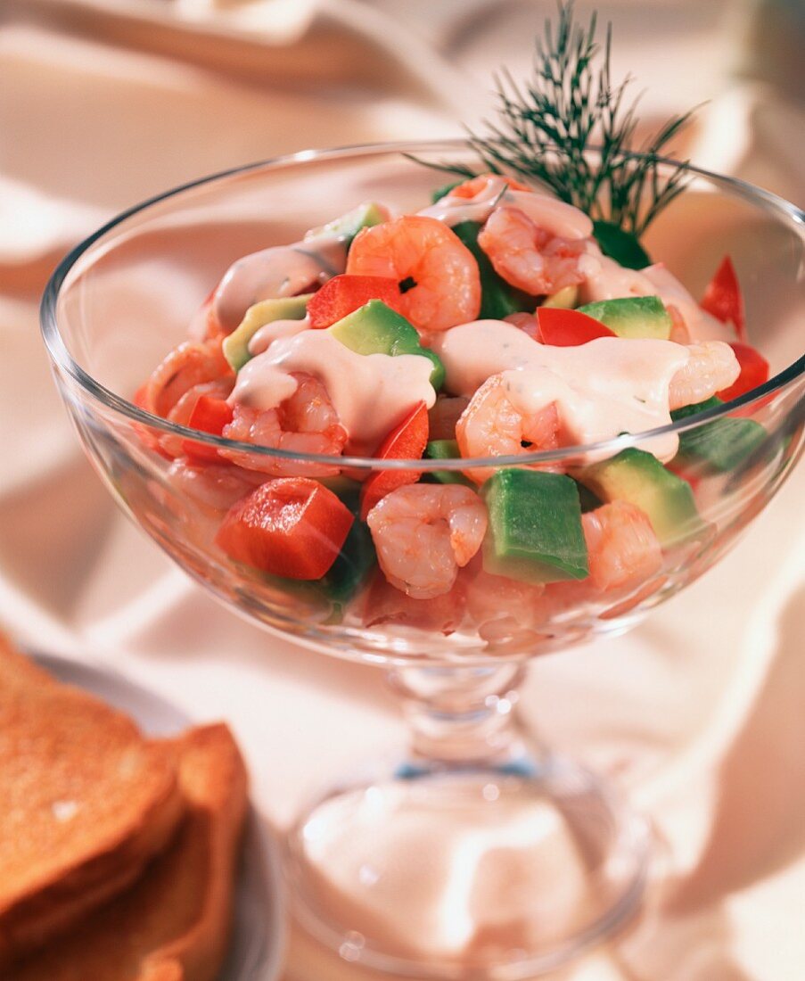 Shrimp cocktail with avocado and paprika in a glass bowl