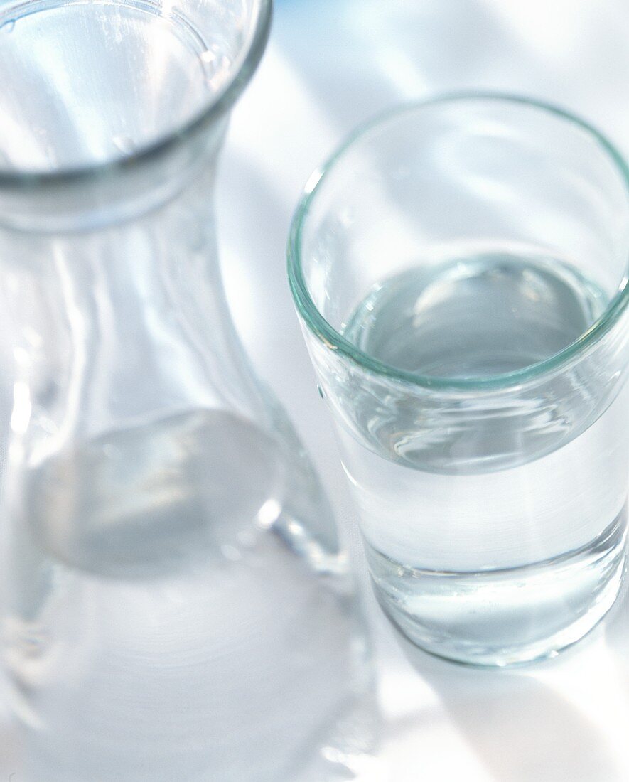 Tafelwasser im Glas und in Glaskaraffe