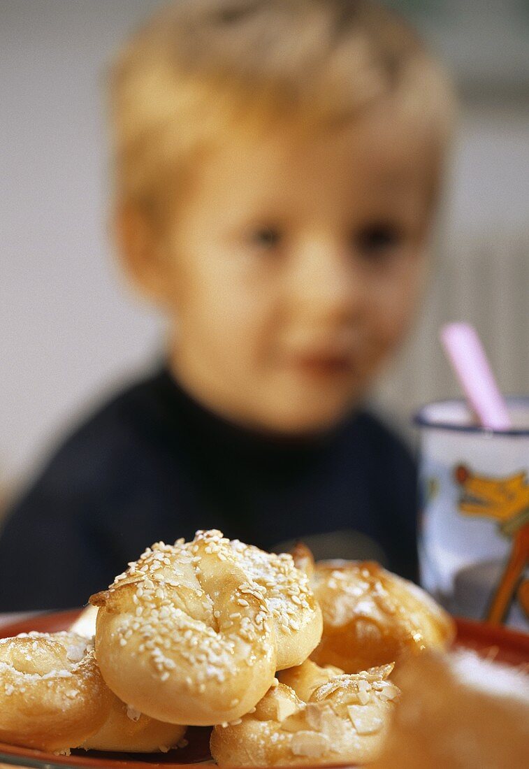 Plate of sweet yeast pastries, with small boy behind