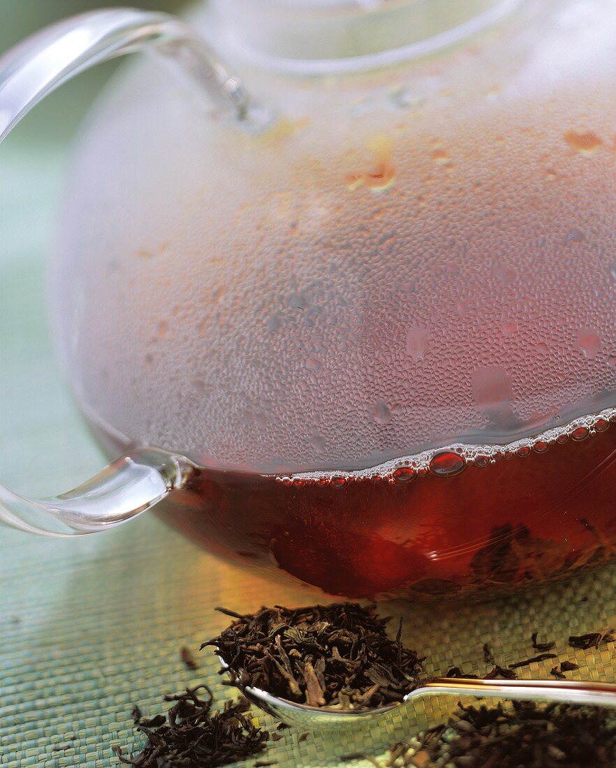 Schwarze Teeblätter & gekochter schwarzer Tee in Glaskanne
