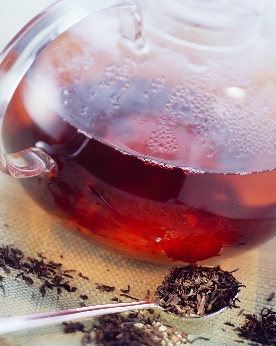 Schwarze Teeblätter & gekochter schwarzer Tee in Glaskanne