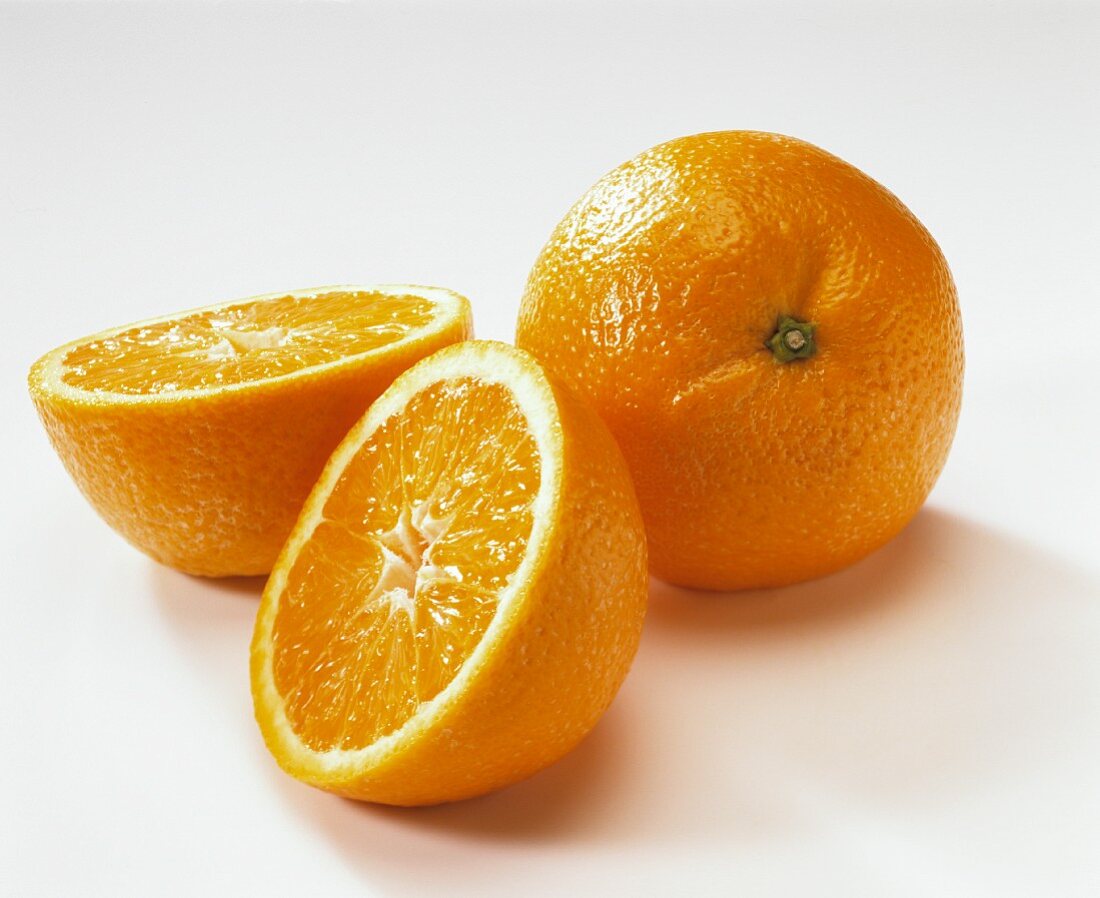Eine halbierte und eine ganze Orange