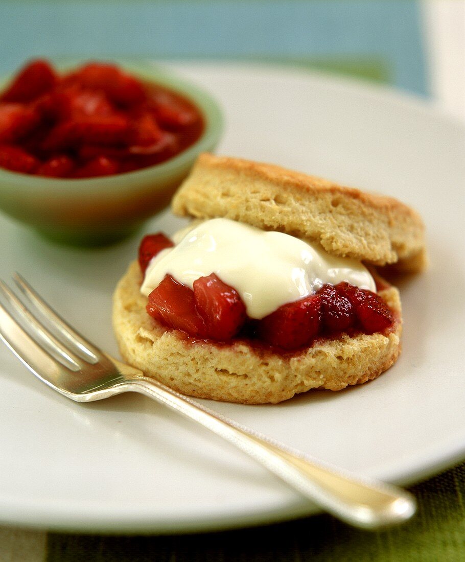 Scone spread with strawberries and vanilla cream