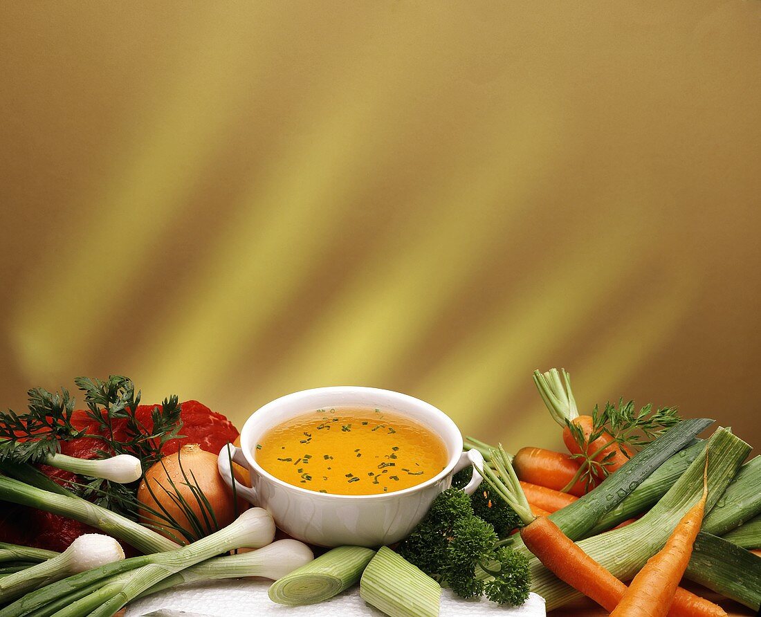 Beef broth in bowl surrounded by ingredients