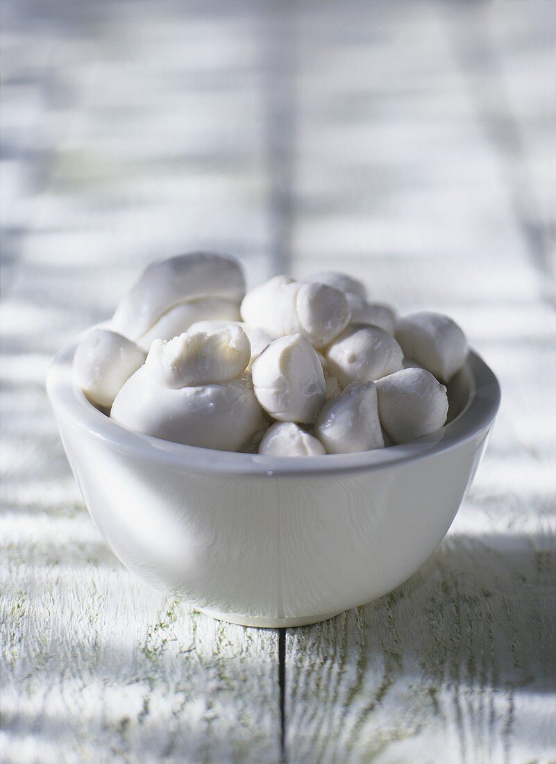 Several mozzarellas in a white bowl