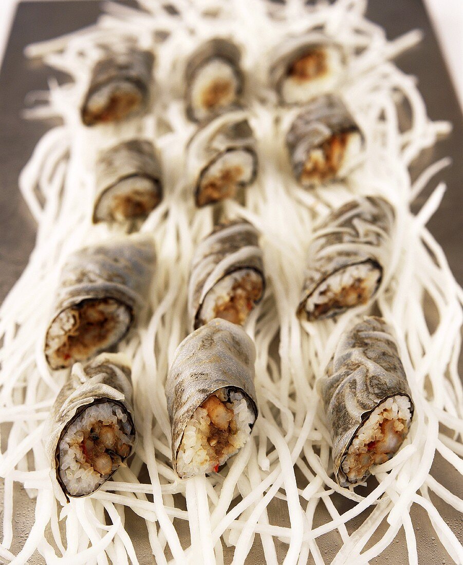 Sushi rolls in rice paper on radish strips