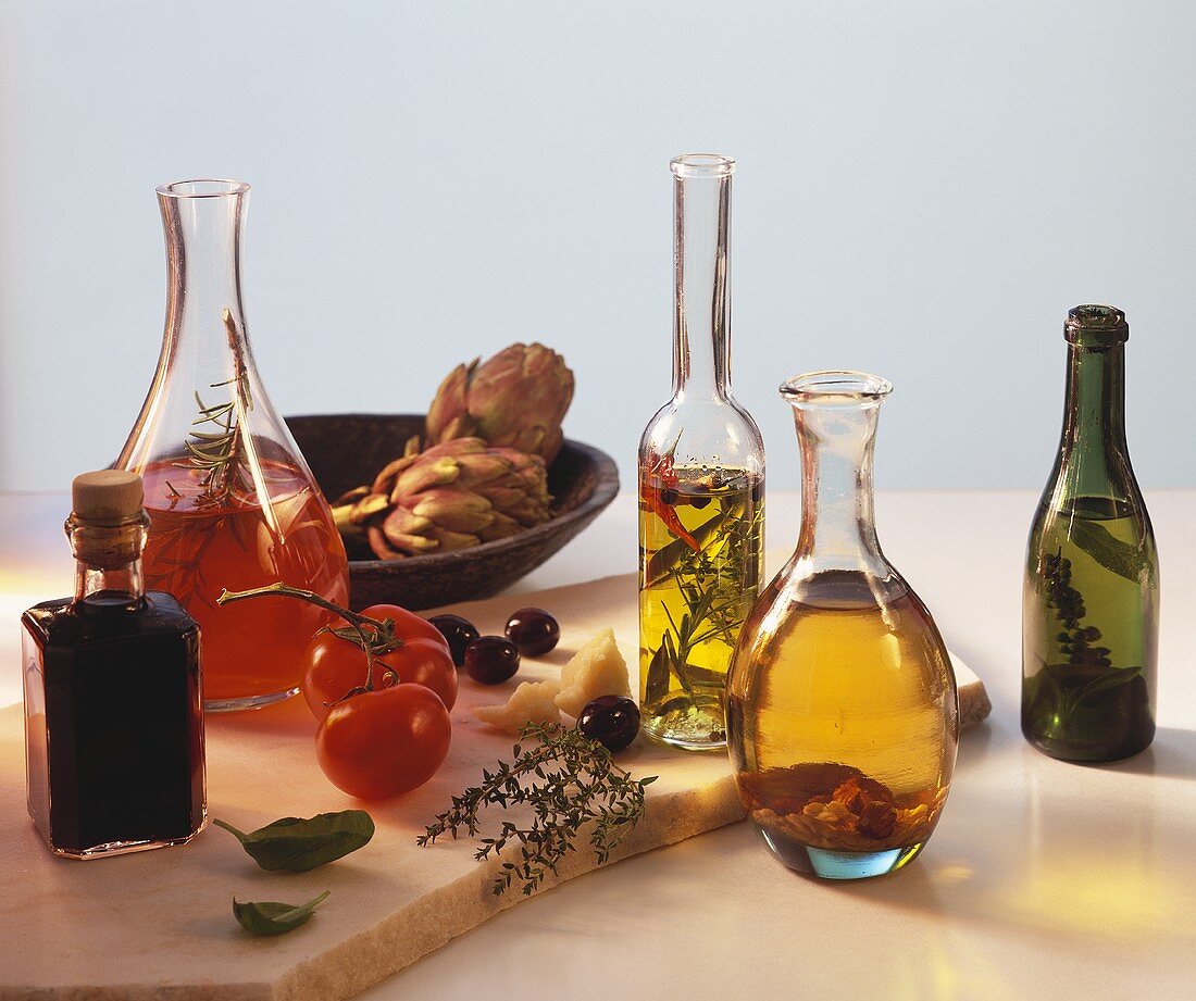 Stillleben mit Essig, Öl, Tomaten, Oliven, Artischocken etc.