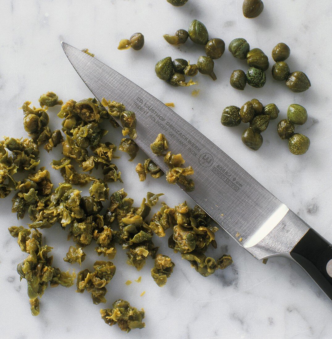 Finely chopping capers