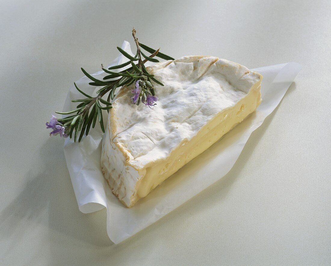 Ein Stück Camembert, garniert mit Rosmarin
