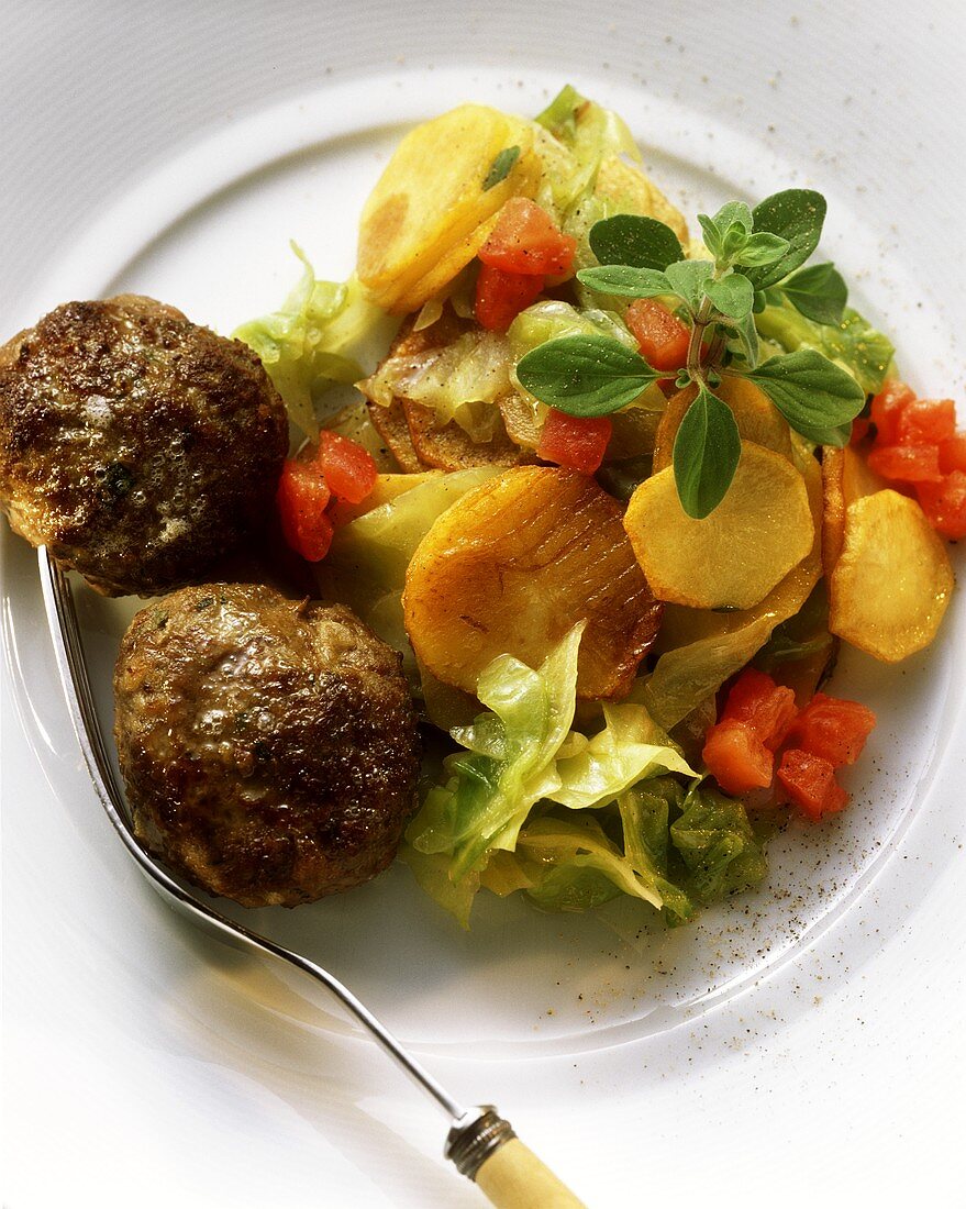 Meatballs with colourful fried potato salad