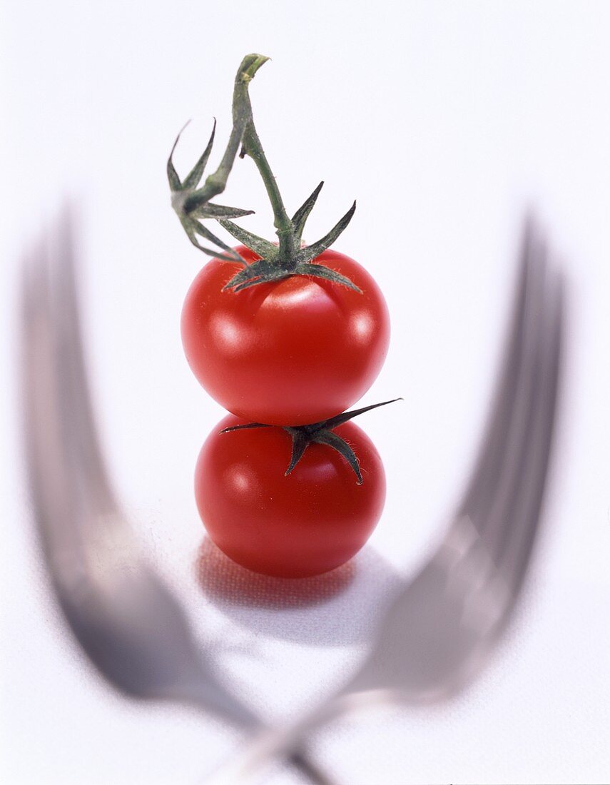Zwei Tomaten umrahmt von zwei Gabeln