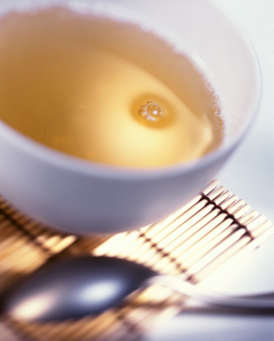 A bowl of tea on bamboo mat