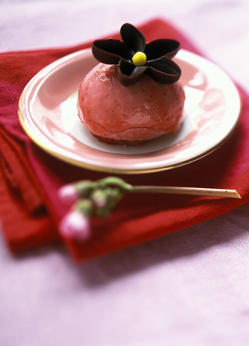 Strawberry ice cream with chocolate flower on sponge base