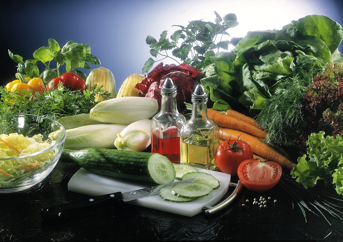 Stillleben mit frischen Salatzutaten (Gemüse,Kräuter,Essig,Öl)