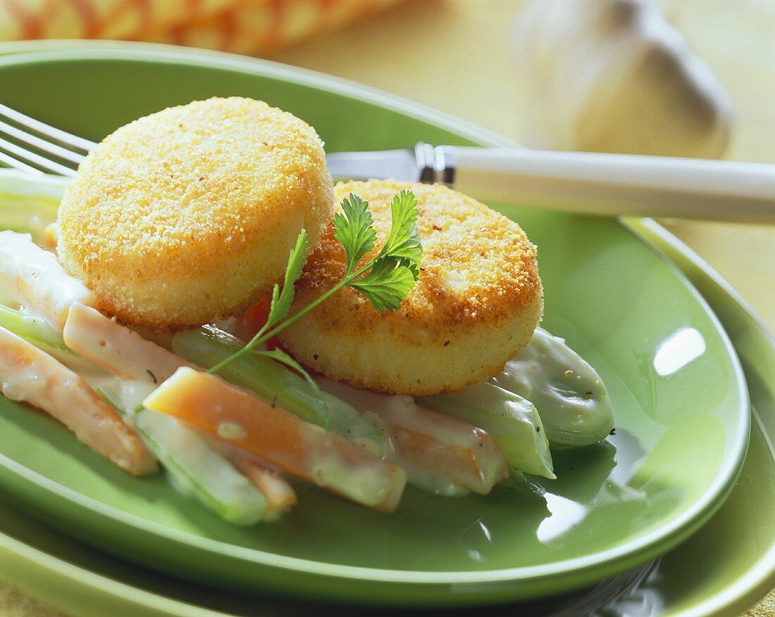 Round rice croquettes on carrots and celery