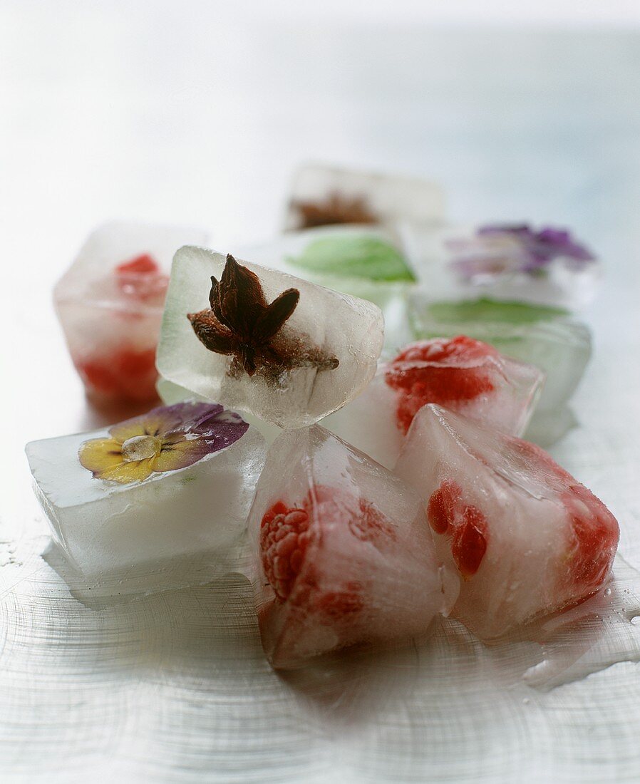 Eiswürfel mit eingeschlossenen Früchten und Blüten