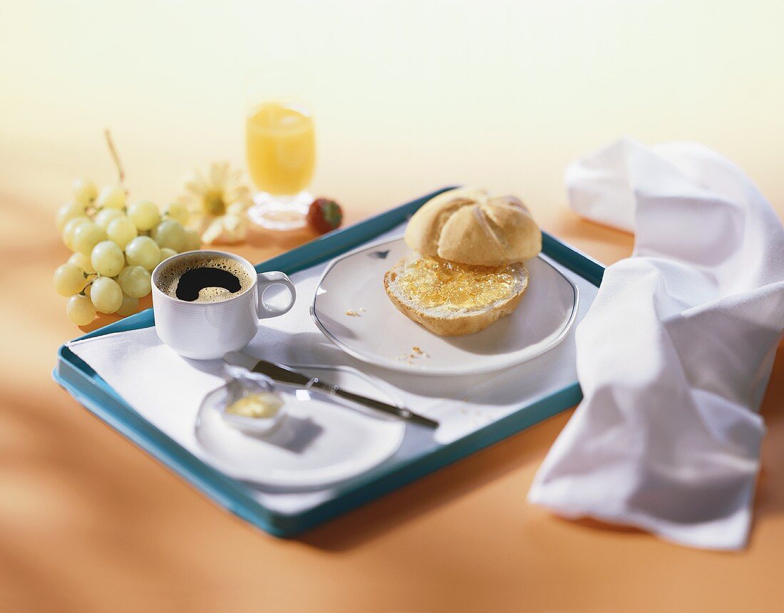 Frühstücktablett mit Marmeladenbrötchen, Butter, Kaffee