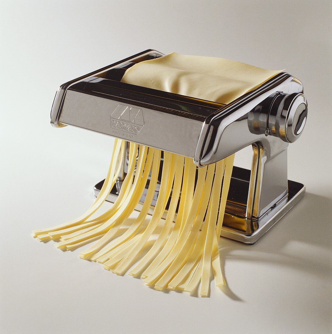 Ribbon pasta coming out of a pasta maker