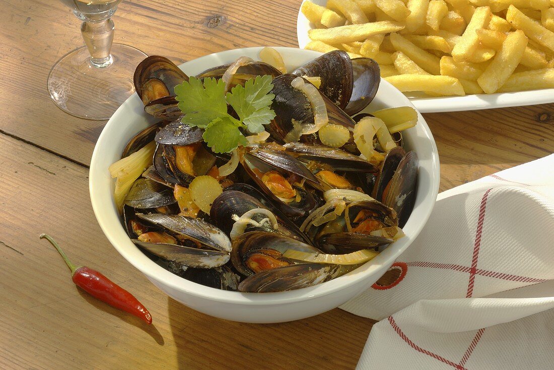 Mussels in vegetable stock, with chips behind