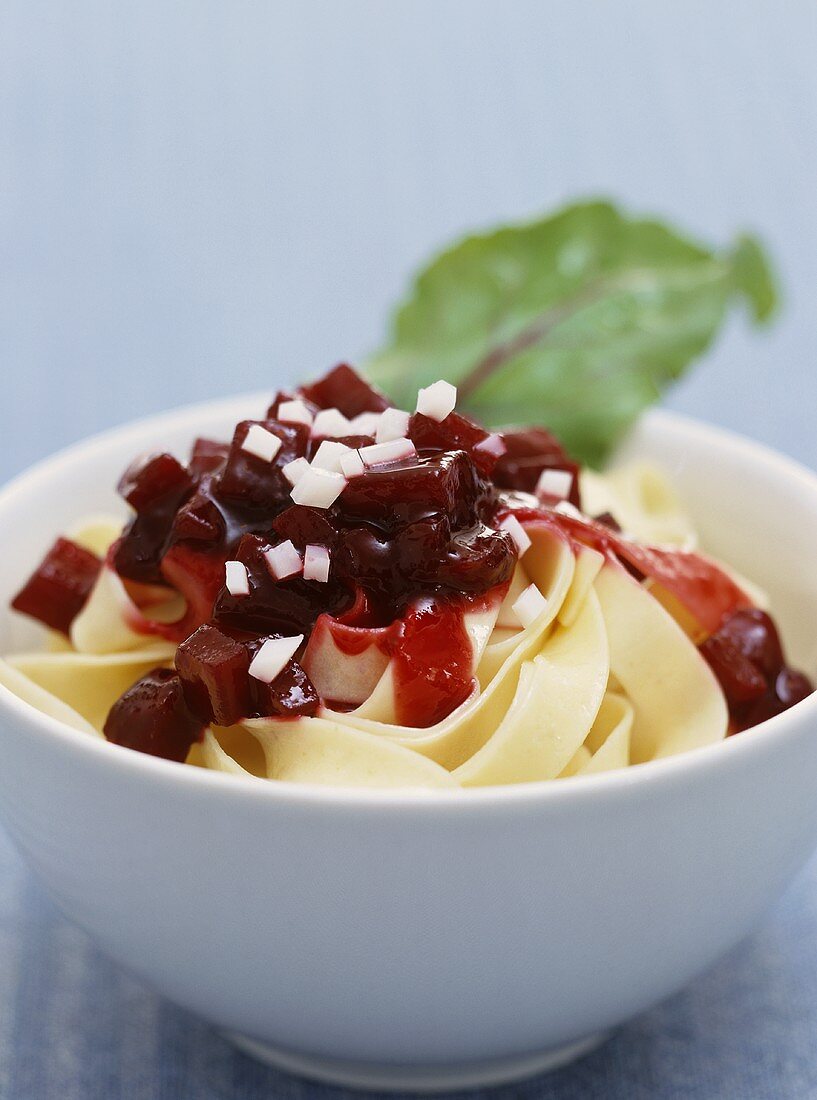 Ribbon noodles with beetroot and goat's cheese in bowl