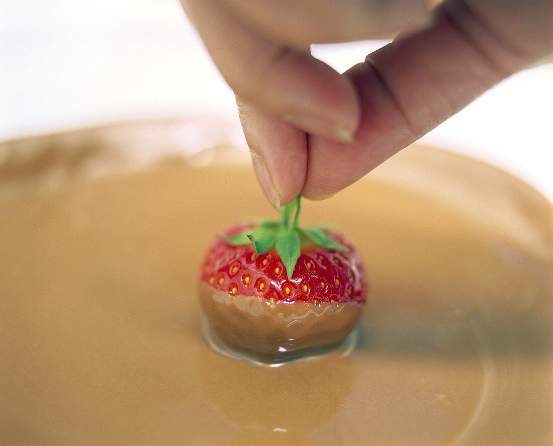 Dipping strawberries in melted chocolate