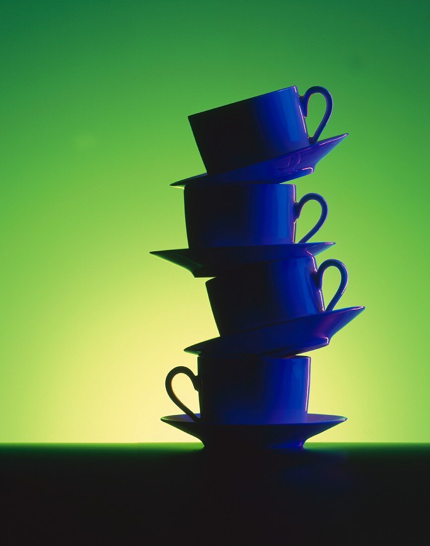 Cups piled up against green background