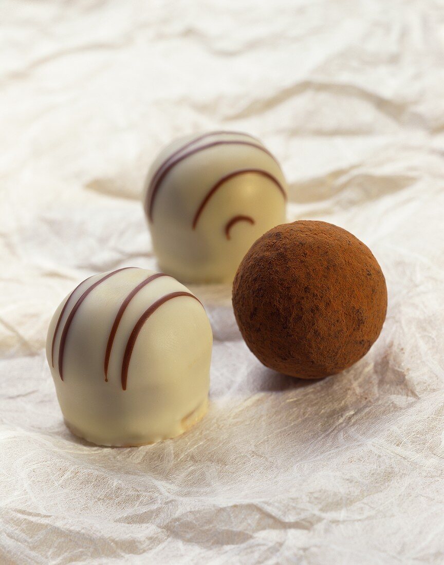 Two chocolates with white chocolate glaze & a truffle