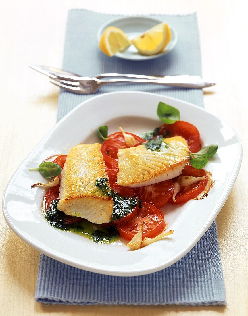 Coley fillet with tomato slices and herb sauce