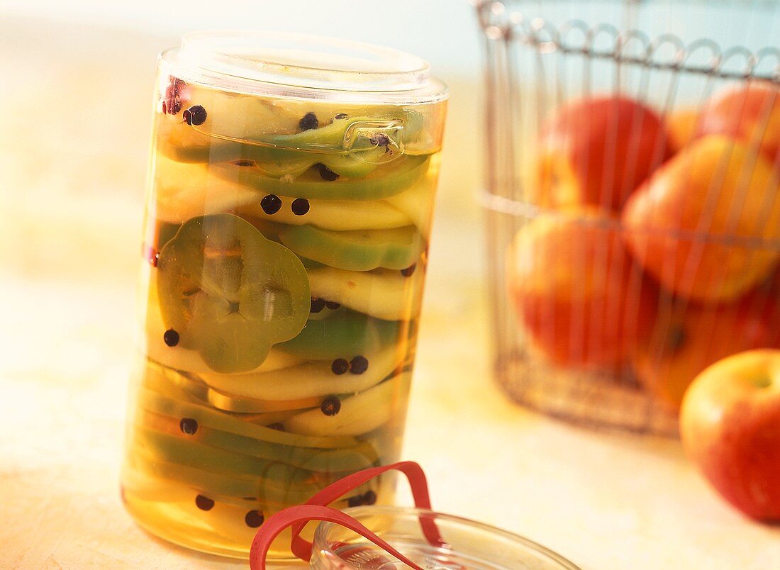 Spicy pickled apple and pepper rings in pickling jar