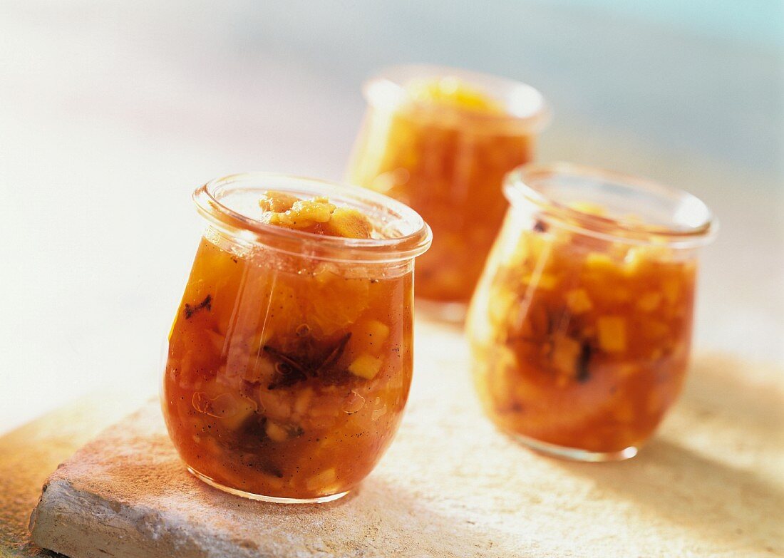 Three jars of spicy bottled papayas in orange liqueur