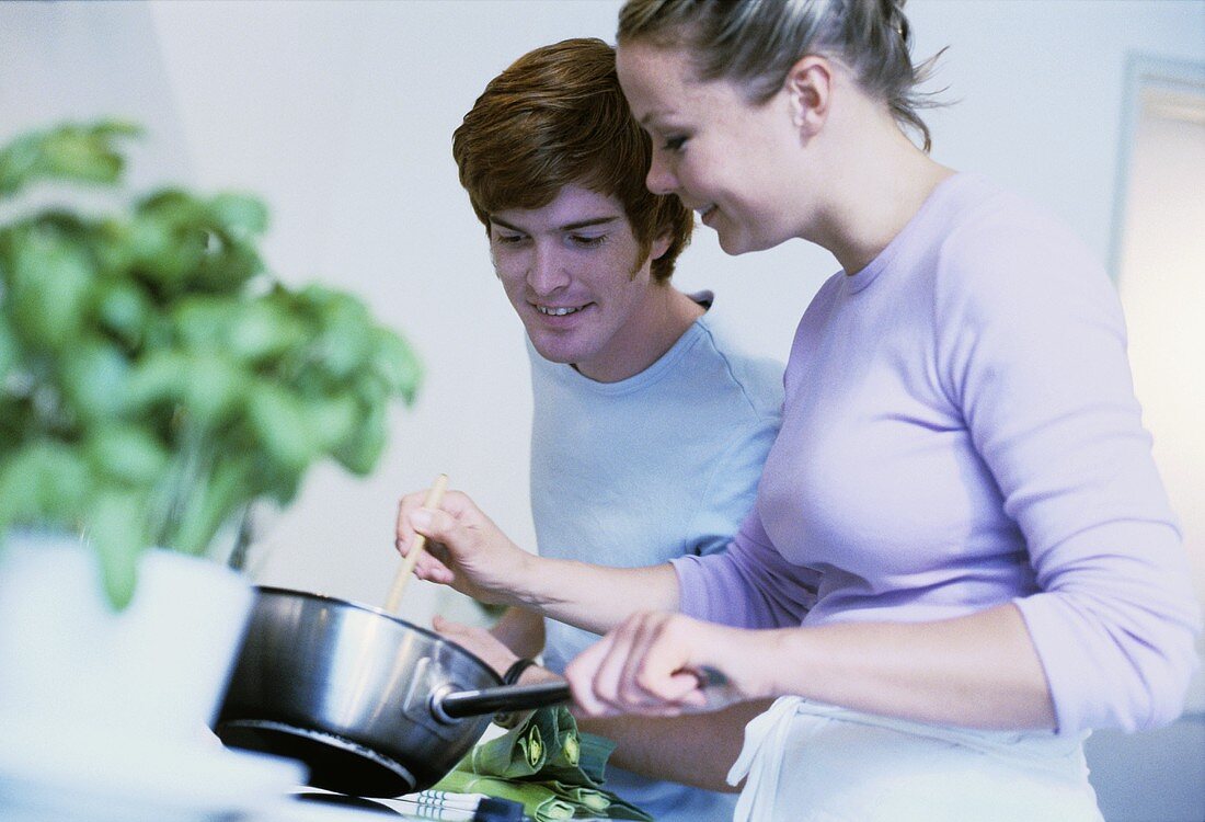 Young couple stirring soup