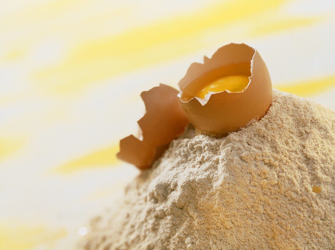 Still life with baking ingredients (egg broken on flour)