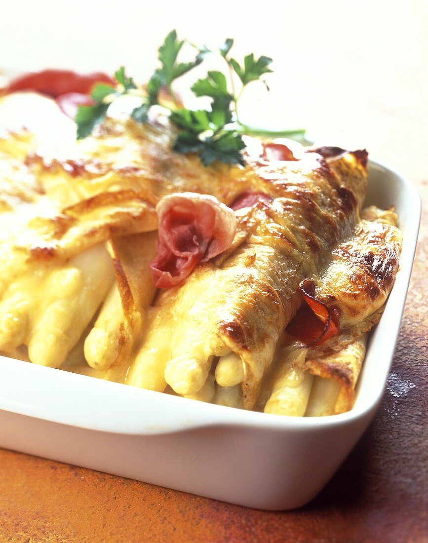 Baked crepes stuffed with white asparagus and ham