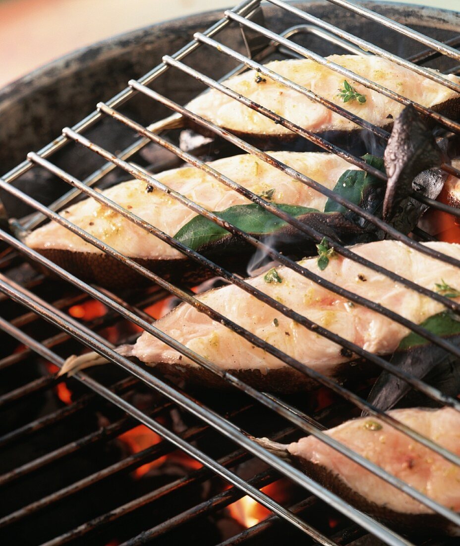 Halibut cutlets with bay leaves on the barbecue