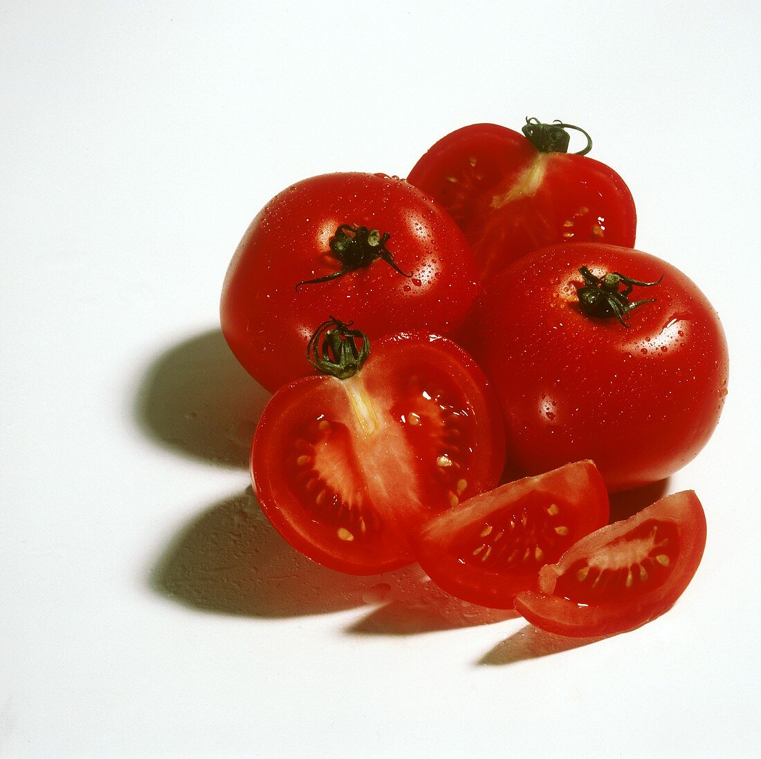 Tomatoes with drops of water, one cut into