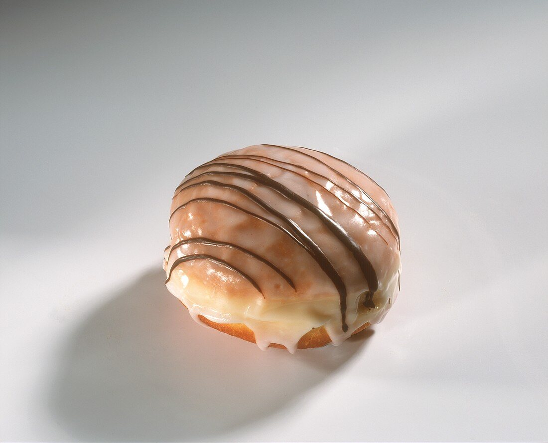 A fritter with icing and with chocolate lines