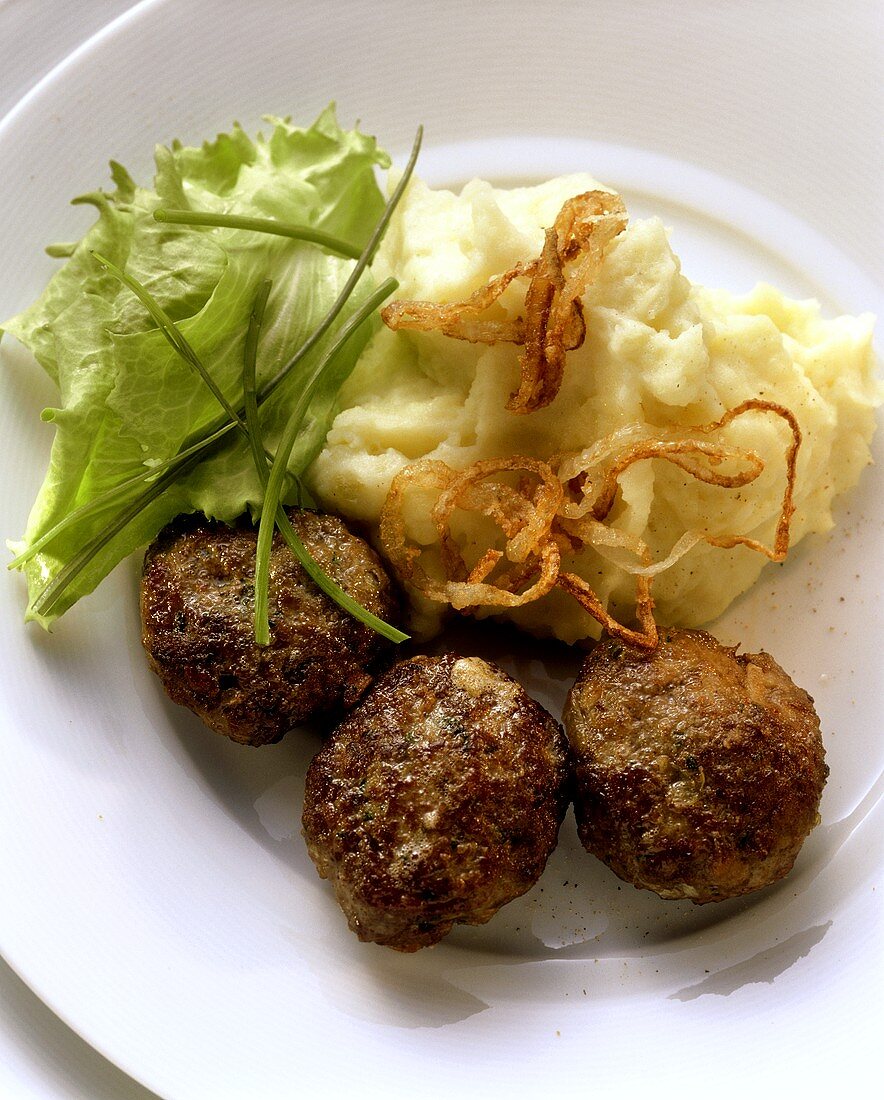 Three rissoles with mashed potato and salad