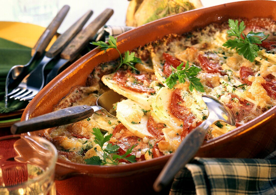 Turnip gratin with tomatoes and cheese in dish