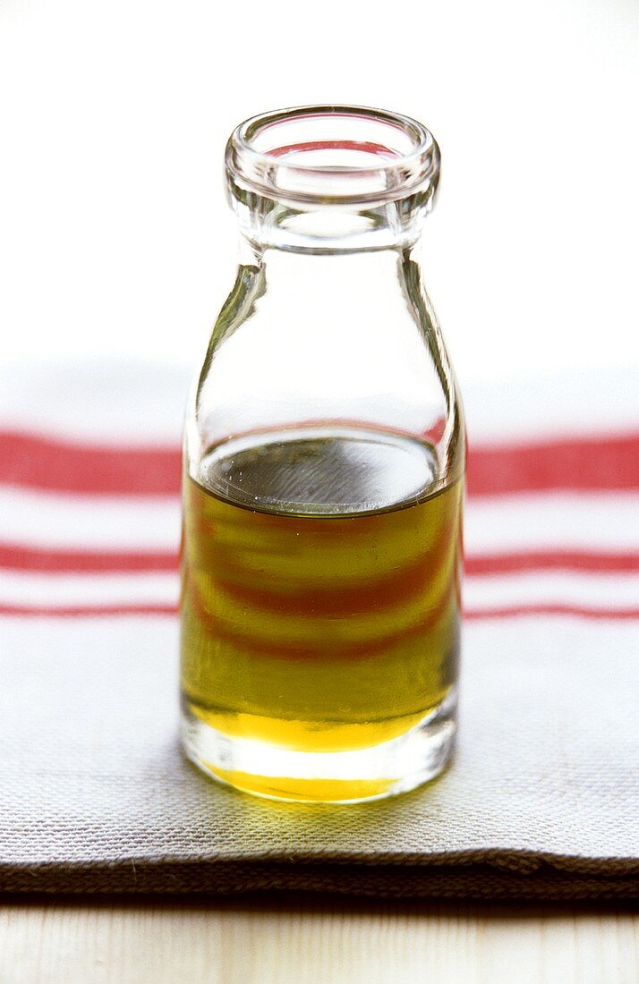 A small bottle of olive oil on kitchen cloth