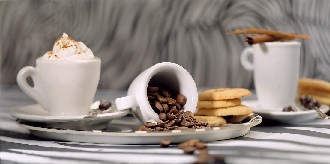 Stillleben mit Kaffeegetränken, Kaffeebohnen und Plätzchen