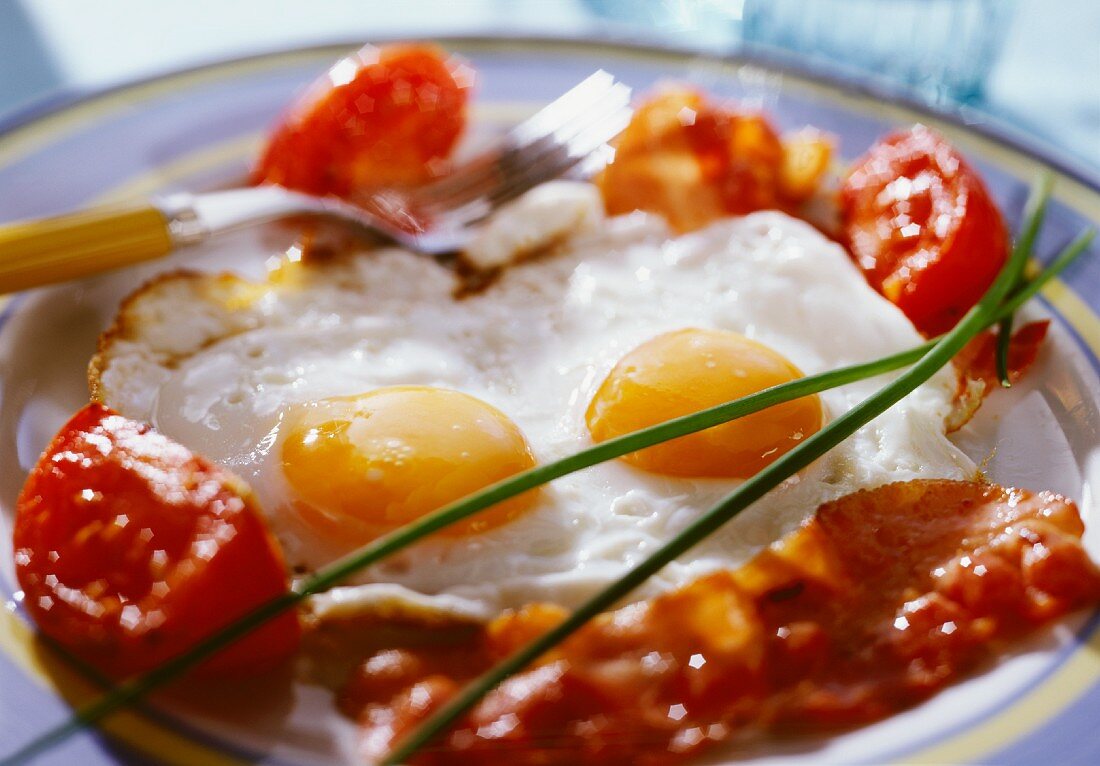 Fried eggs with bacon and tomatoes