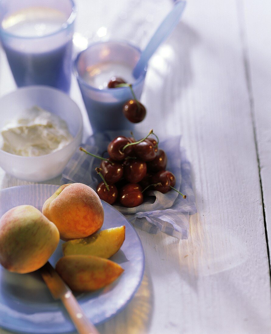 Früchtestilleben mit Pfirsichen, Kirschen, Quark und Joghurt