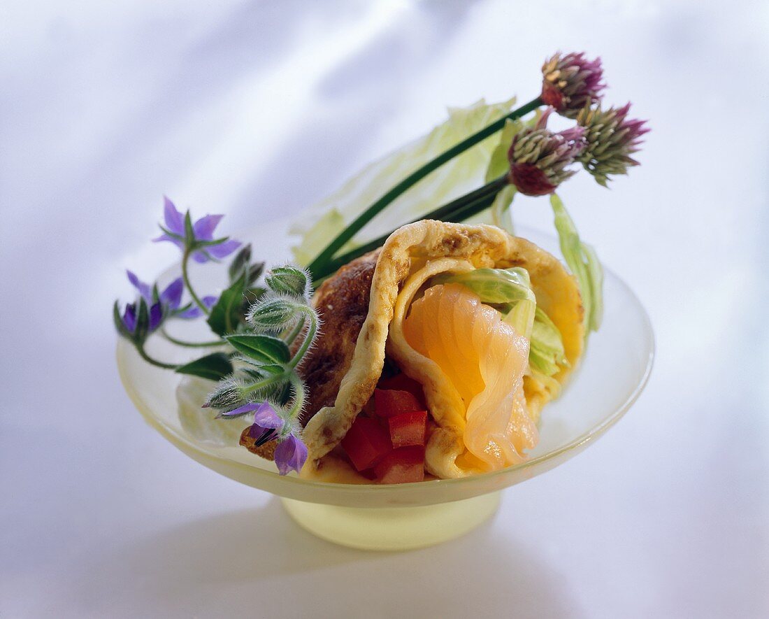 Filled pancake with salmon, salad leaves and tomato