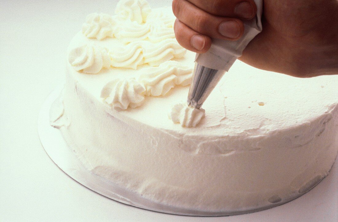 Decorating a sponge cake with cream