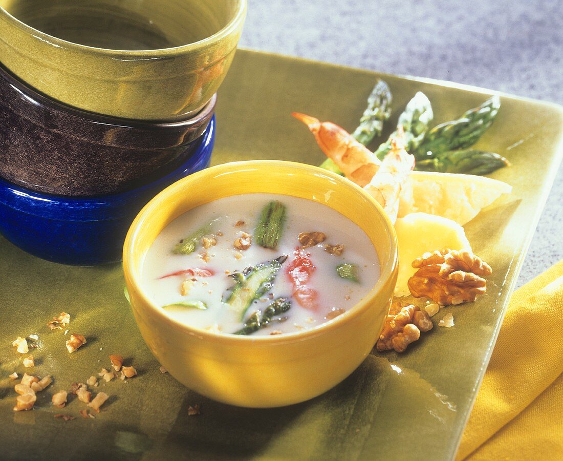 Creamed cheese soup with green asparagus and shrimps
