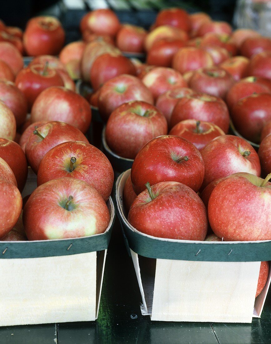 Rote Äpfel in Holzschälchen auf einem Marktstand