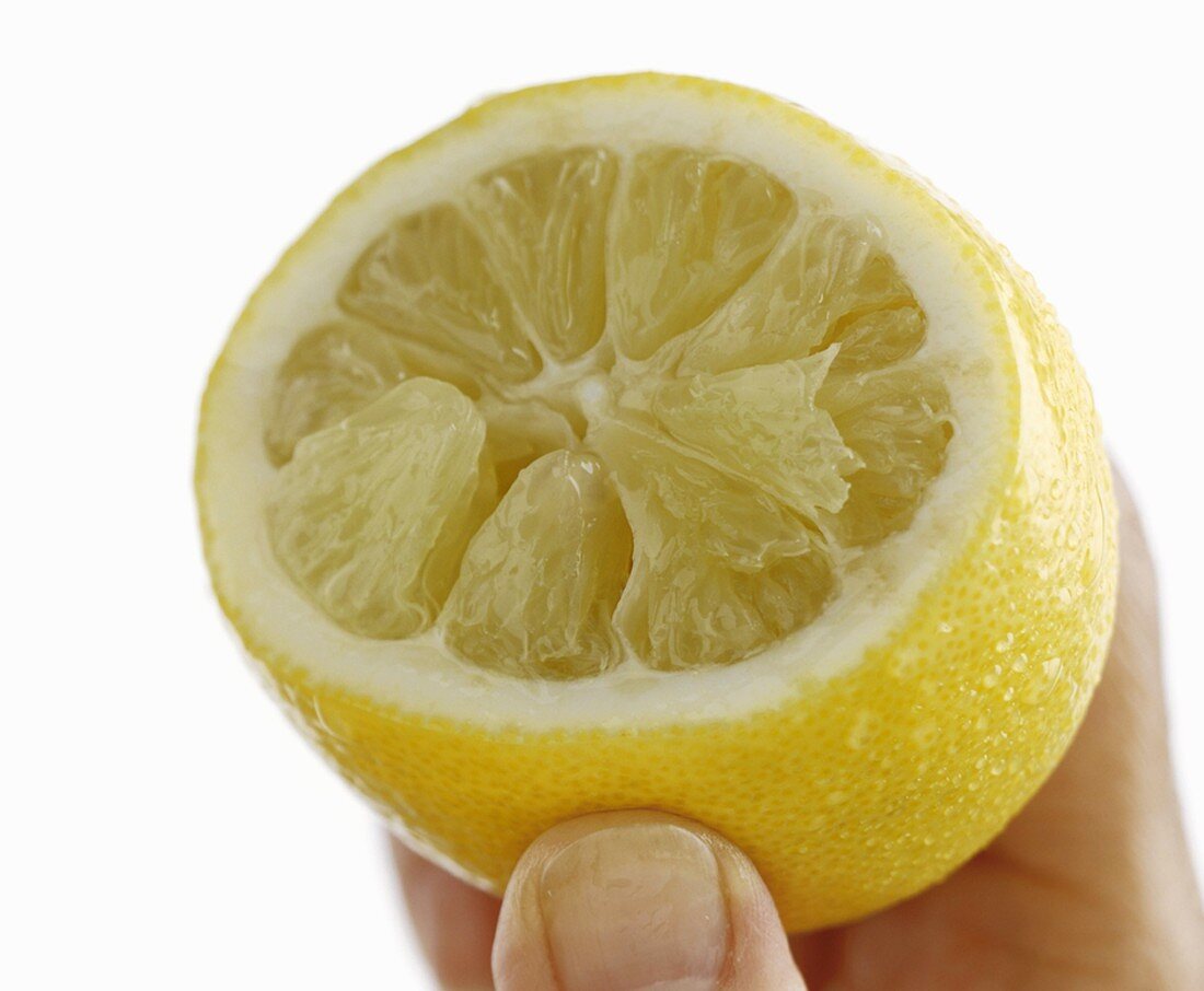 Ausgepresste Zitrone in einer Hand